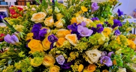 Casket spray in yellows and purples