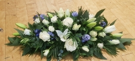 White Lily casket spray with a touch of blue